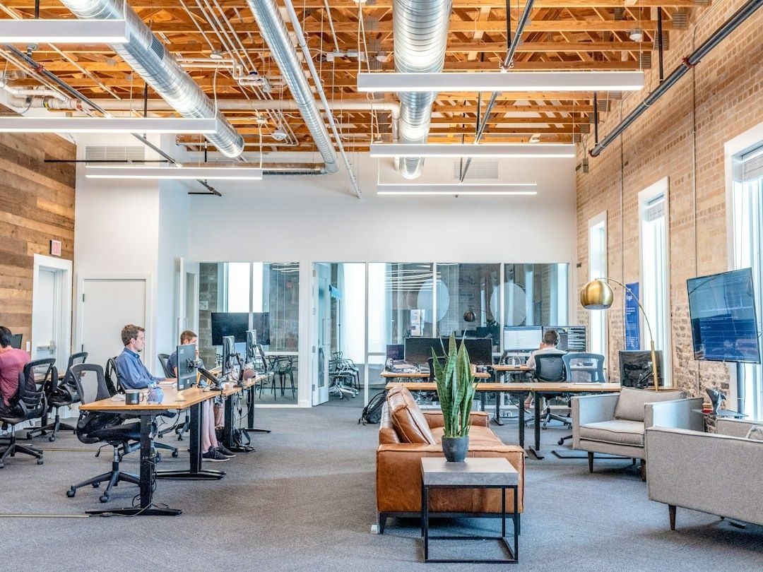 Modernes Büro mit Mitarbeitenden an Computern und digitalen Arbeitsplätzen